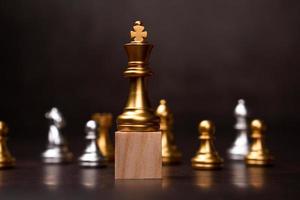 xadrez rei dourado em pé em um suporte de madeira. o conceito de líderes em boas organizações deve ter visão e pode prever tendências de negócios e avaliar concorrentes foto