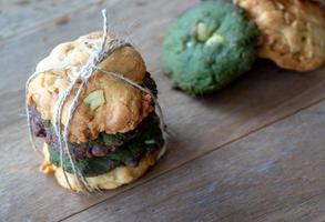 biscoitos de várias cores, incluindo manteiga de amendoim, biscoitos de chá verde e biscoitos de chocolate. sobreposto por cores alternadas na mesa de madeira. foto