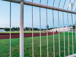 o estádio cercado onde as pessoas estão se exercitando é correr, caminhar, chutar futebol e assim por diante, há muitas atividades para fazer. foto