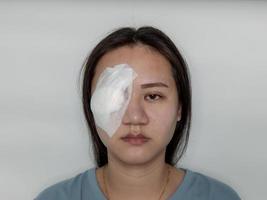 mulher do olho sistêmico sendo tratada da doença do hordéolo perfurando e raspando o pus e cobrindo-o com um pano de gaze. foto