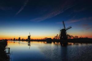 colorido primavera pôr do sol tradicional canal holandês de moinhos de vento em rott foto