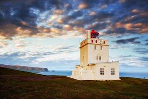 lindo farol branco no cabo dyrholaey, sul da islândia foto