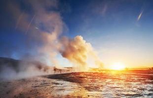 fantástica erupção do gêiser strokkur do pôr do sol na islândia foto
