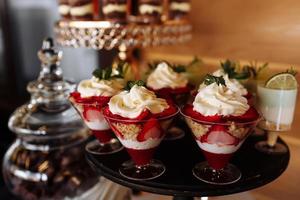 mesa com doces coloridos e guloseimas para a recepção da festa de casamento, mesa de sobremesa de decoração. deliciosos doces no buffet de doces. mesa de sobremesa para uma festa. bolos, bolinhos. foco seletivo. foto