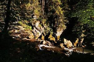 rio de montanha rápido ao pôr do sol nas montanhas dos cárpatos foto