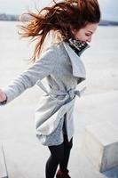 pulando garota modelo engraçada feliz no casaco cinza. foto