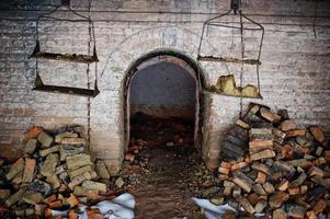 túnel de arco de tijolo assustador no escuro e um pouco de luz. foto