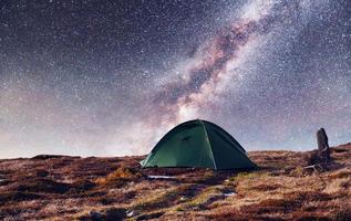 o céu estrelado acima da tenda nas montanhas. evento mágico em f foto