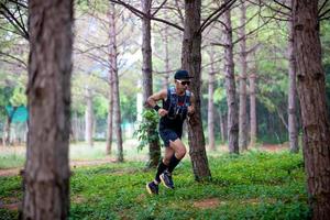 um homem corredor de trilha e pés de atleta usando sapatos esportivos para trilha na floresta foto