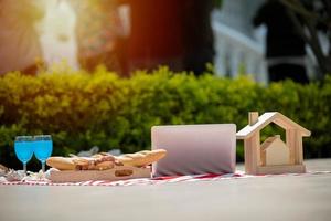 cesta de piquenique com comida e bebida no cobertor. piquenique almoço ao ar livre em um campo em dia ensolarado com pão foto