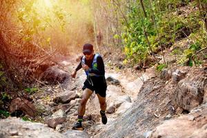um homem corredor de trilha e pés de atleta usando sapatos esportivos para trilha na floresta foto
