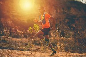 um homem corredor de trilha e pés de atleta usando sapatos esportivos para trilha na montanha foto