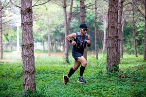 um homem corredor de trilha e pés de atleta usando sapatos esportivos para trilha na floresta foto