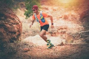 um homem corredor de trilha e pés de atleta usando sapatos esportivos para trilha na montanha foto