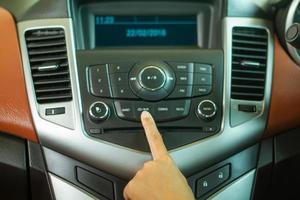 mulheres asiáticas pressionam o botão do rádio do carro para ouvir música. foto