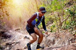 um homem corredor de trilha e pés de atleta usando sapatos esportivos para trilha na floresta foto