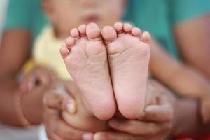 mãos de mãe e pés de crianças foto