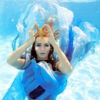 retrato de moda subaquática de mulher jovem e bonita de vestido azul foto