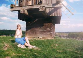 jovem loira linda com cabelo comprido em campo verde na aldeia étnica ao ar livre em kyiv ucrânia foto