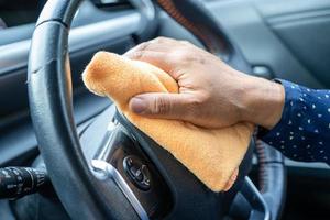 nova normal, mulher asiática trabalhadora limpa no carro pela imprensa azul álcool gel desinfetante para proteger o coronavírus de segurança. foto