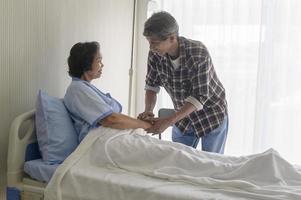 homem sênior visitando mulher paciente sênior no hospital, cuidados de saúde e conceito médico foto