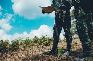 soldados estão usando o rádio. e use o mapa para comunicação entre as operações militares na floresta de fronteira. guardião foto