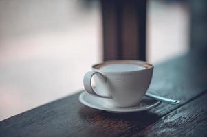 uma xícara de café e grãos de café na mesa de café para amantes de café. foto