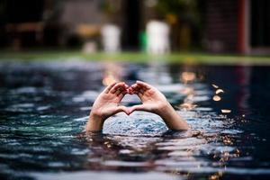 amo a mão na piscina. dê a um ente querido. localizado no lado da água da piscina. foto