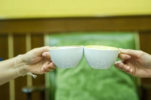 mão e café e chá verde quente os jovens gostam de beber bebidas quentes. conceitos de comida e bebida de café saudável foto
