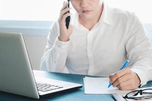 jovens asiáticos atendem o telefone felizes após um novo pedido do cliente, empresário que trabalha em embalagem de escritório em casa em segundo plano, comércio eletrônico de compras on-line ou conceito de trabalho freelance. foto