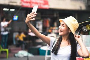 selfie jovem mulher asiática com tuktuk foto