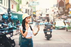 mulher asiática usando smartphone na estrada khaosan foto