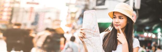 mulher asiática pesquisando com mapa em chinatown foto