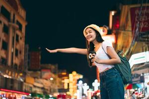 mulher adulta jovem viajante solo asiático chama táxi à noite foto