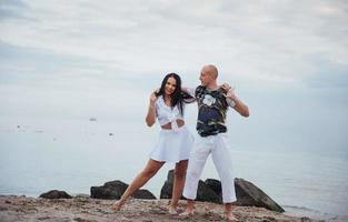 lindo casal inflamatório dançando na praia foto