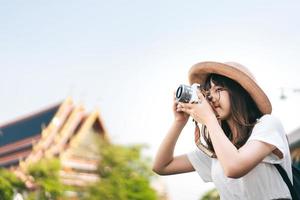 jovem viajante asiática passear ao redor de bangkok com a câmera. foto