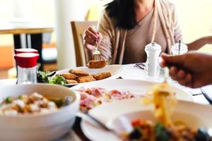 refeição de comida italiana no restaurante com pessoas comendo fundo no dia com luz natural foto