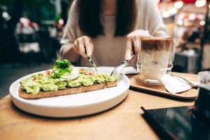 comida saudável de abacate guacamole e fundo de mulher asiática no restaurante ao ar livre no dia foto