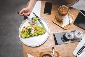 comida saudável de abacate guacamole e fundo de mulher asiática no restaurante ao ar livre no dia foto