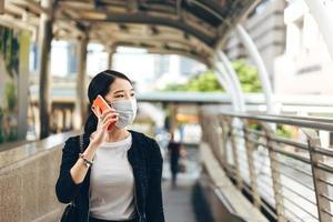 mulher trabalhadora asiática de negócios jovem adulta usa máscara facial para proteger a coroa do vírus ou covid19 e a poluição do ar. foto