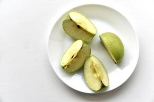 fatias de maçã verde em um prato branco foto