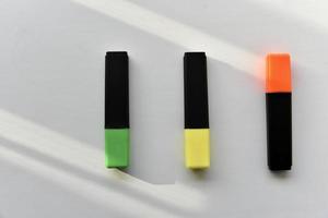 marcadores coloridos em um fundo branco à luz foto