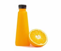 uma garrafa cheia de suco de laranja e um cítrico meio cortado encostado na garrafa de suco de laranja em um fundo branco. foto