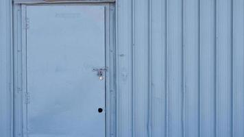 porta do armazém para armazenamento. a porta de metal forte tem um cadeado. padrão de parede, padrão de recipiente. armários ou armazéns. foto