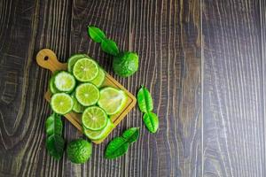 fatias de frutas frescas de bergamota em madeira foto