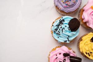deliciosos cupcakes caseiros com creme colorido e cobertura com biscoitos doces e chocolate. sobremesa caseira de férias de outono foto