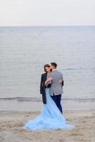 sessão de fotos de casamento de um casal à beira-mar. vestido de noiva azul na noiva.