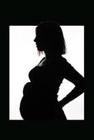 elegante linda mulher grávida em um vestido preto mantém as mãos na barriga. foto