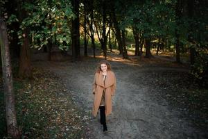 linda mulher elegante em pé em um parque no outono foto