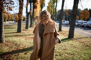 linda mulher elegante em pé em um parque no outono foto